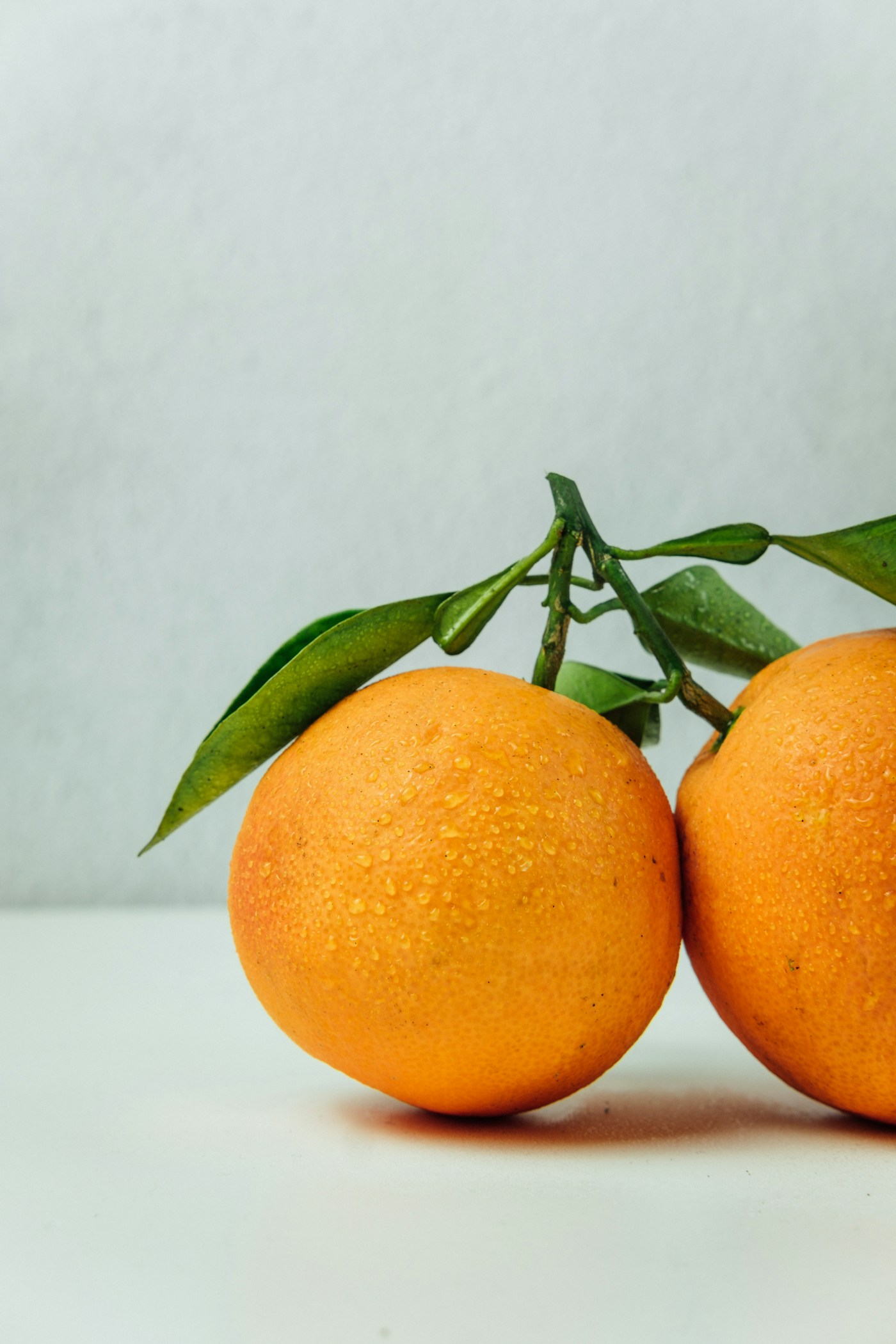 Still life of fresh oranges with green leaves
